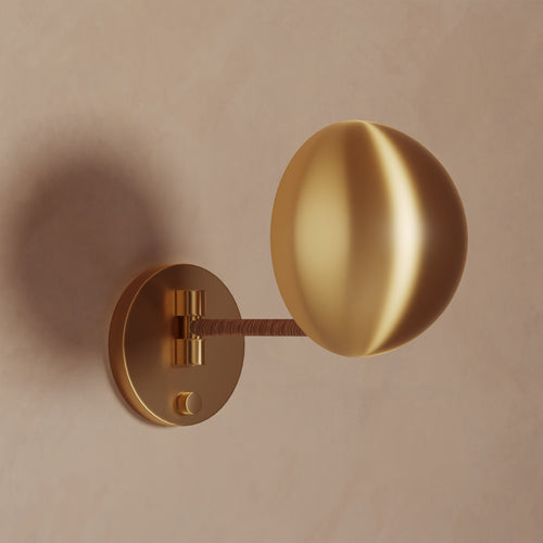 Lemieux et Cie Chambord Sconce in warm brass, sculptural wall light with organic spherical shade and circular backplate on neutral plaster wall.
