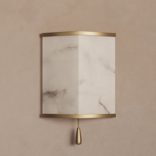 Lemieux et Cie Cleor Small LED Sconce, wall-mounted fixture with cylindrical marble shade and brass frame, shown on warm neutral plaster wall.