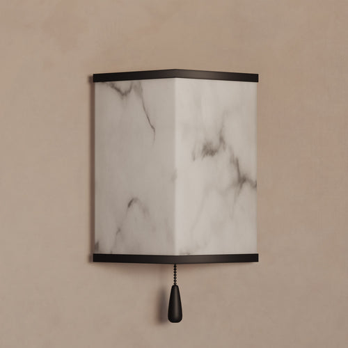 Lemieux et Cie Cleor Small LED Sconce with marble shade and dark trim, wall-mounted sconce with pull chain on warm neutral wall.