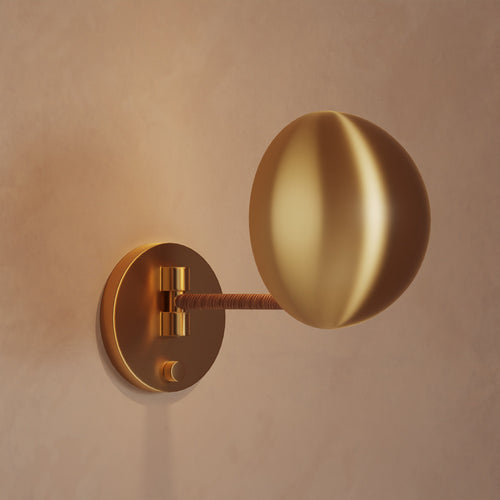 Lemieux et Cie Chambord Sconce in warm brass, sculptural wall light with organic rounded shade and articulated arm, shown on neutral plaster wall.
