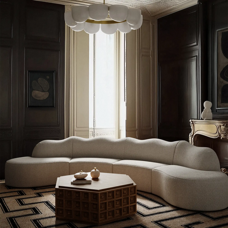 Lemieux Et Cie serpentine 4 piece duboiscoffee cheverny marquiserug PEMart caillou imanesculptureModern living room with a curved beige sofa, wooden coffee table, and decorative elements. 
