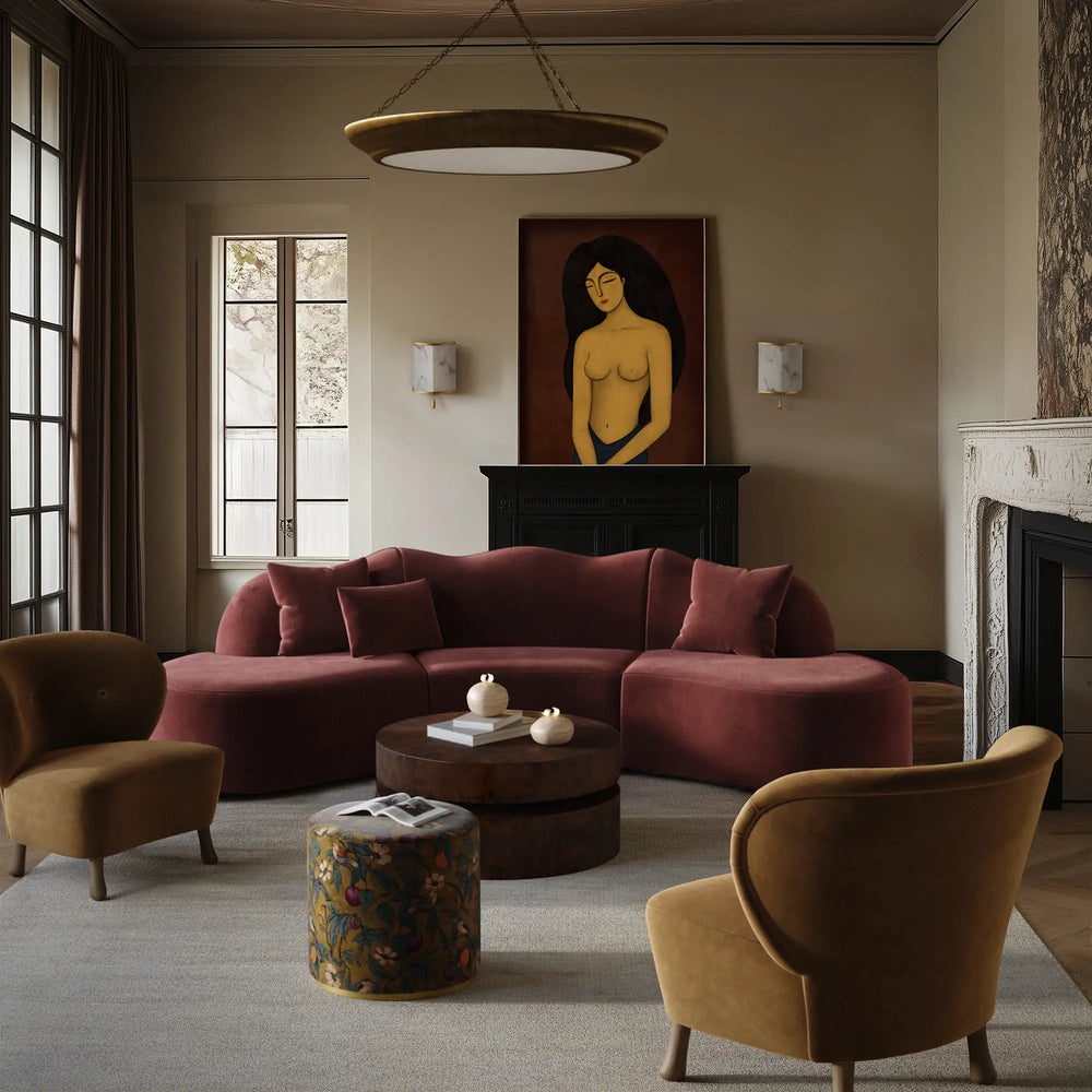 Lemieux et Cie Serpentine Sectional Sofa in rose upholstery, curved modular seating with rounded chaise, styled in a sitting room with neutral walls and fireplace.