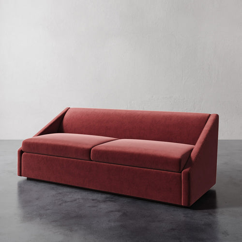 Lemieux et Cie Fontaine Sofa in terracotta upholstery, architectural sofa with structured silhouette, shown on dark concrete floor against textured plaster walls.
