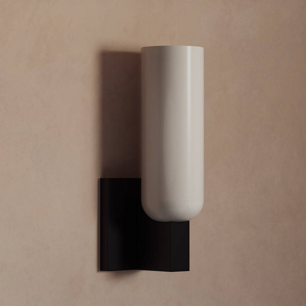Lemieux et Cie Maroux Single Sconce with cylindrical ivory shade and dark geometric wall mount, wall sconce on warm neutral plaster wall
