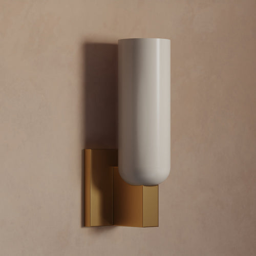 Lemieux et Cie Maroux Single Sconce with cylindrical shade and brass backplate, wall-mounted sconce against warm neutral plaster wall in soft light.