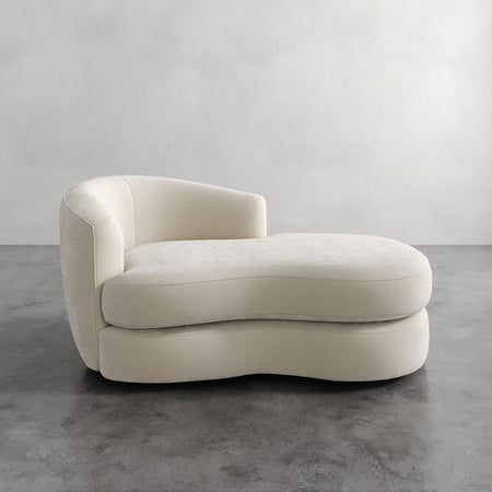 Lemieux et Cie Rulmann Left Arm Chaise in ivory, sculptural curved chaise with organic low-slung form, shown on concrete floor against neutral walls.