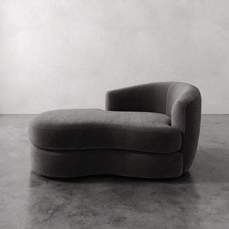 Lemieux et Cie Rulmann Right Arm Chaise in charcoal, sculptural low-slung chaise with rounded arms, shown on polished concrete floor against neutral walls.