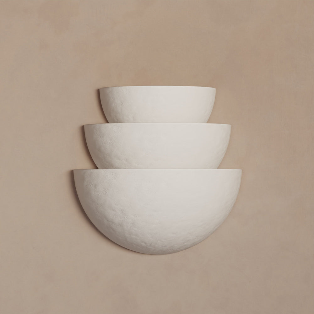 Lemieux et Cie Argan Collection tiered plaster sconce in white, three stacked bowl forms on warm neutral wall in soft light.
