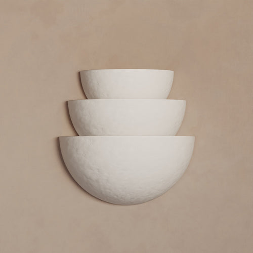 Lemieux et Cie Argan Collection tiered plaster sconce in white, three stacked bowl forms on warm neutral wall in soft light.