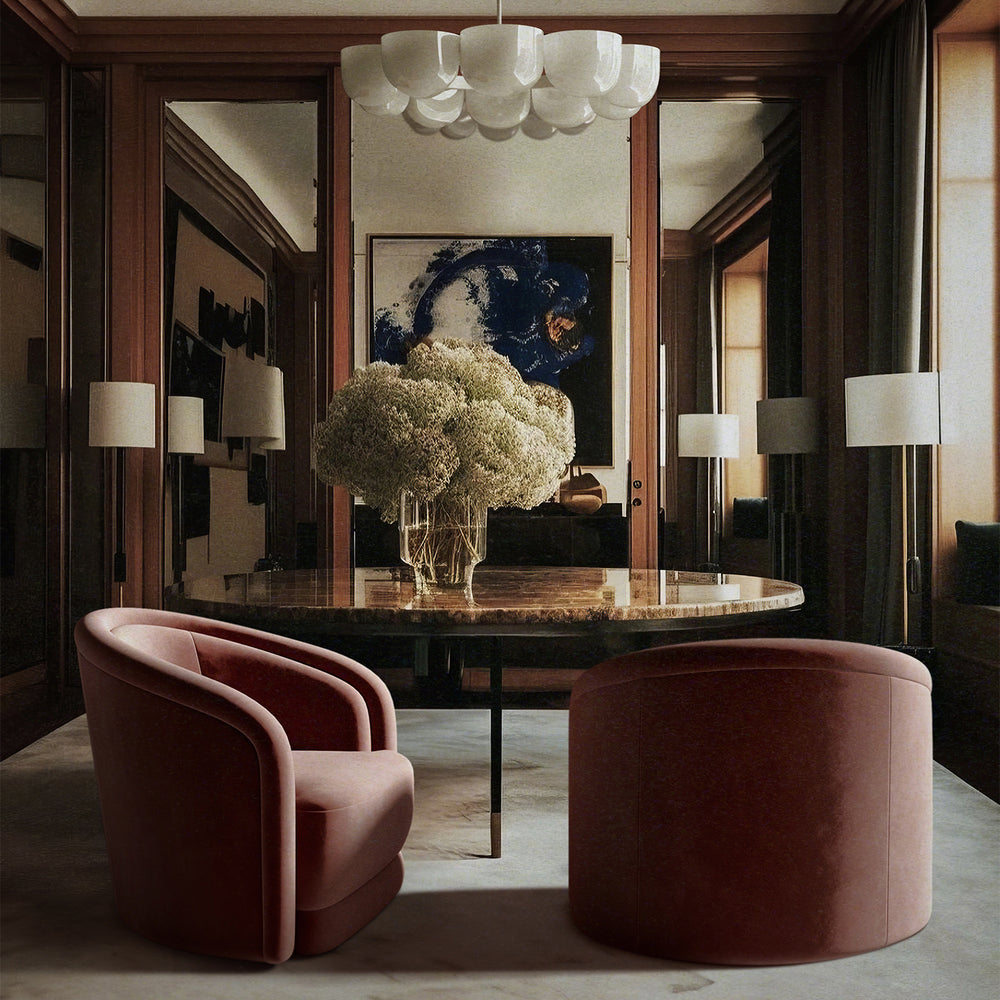 Lemieux et Cie Valence Swivel Chair in blush and rust tones, rounded barrel-back seating, styled around marble-top dining table in wood-paneled room with chandelier overhead.