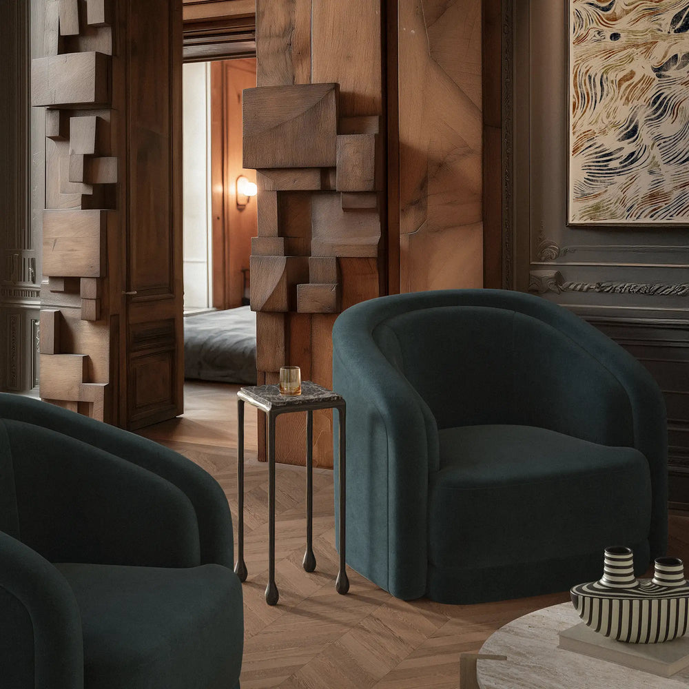 Lemieux et Cie Ravelle Drinks Table with honed Emperador marble top and aged bronze iron frame, accent table beside deep teal seating in wood-paneled room.