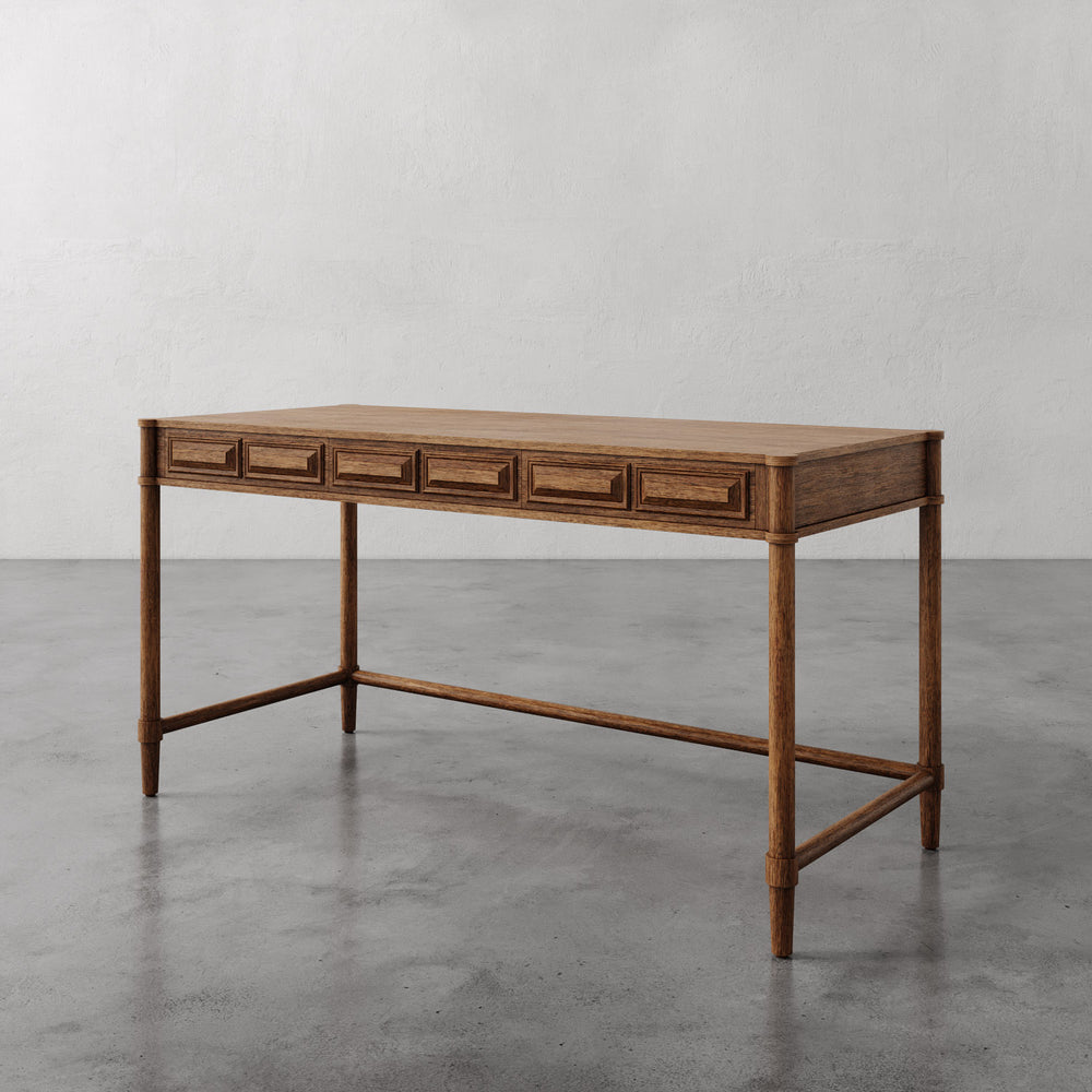 Lemieux et Cie Voltaire Desk in wire-brushed oak, desk with three full-width drawers, shown on polished concrete floor against white plaster walls.