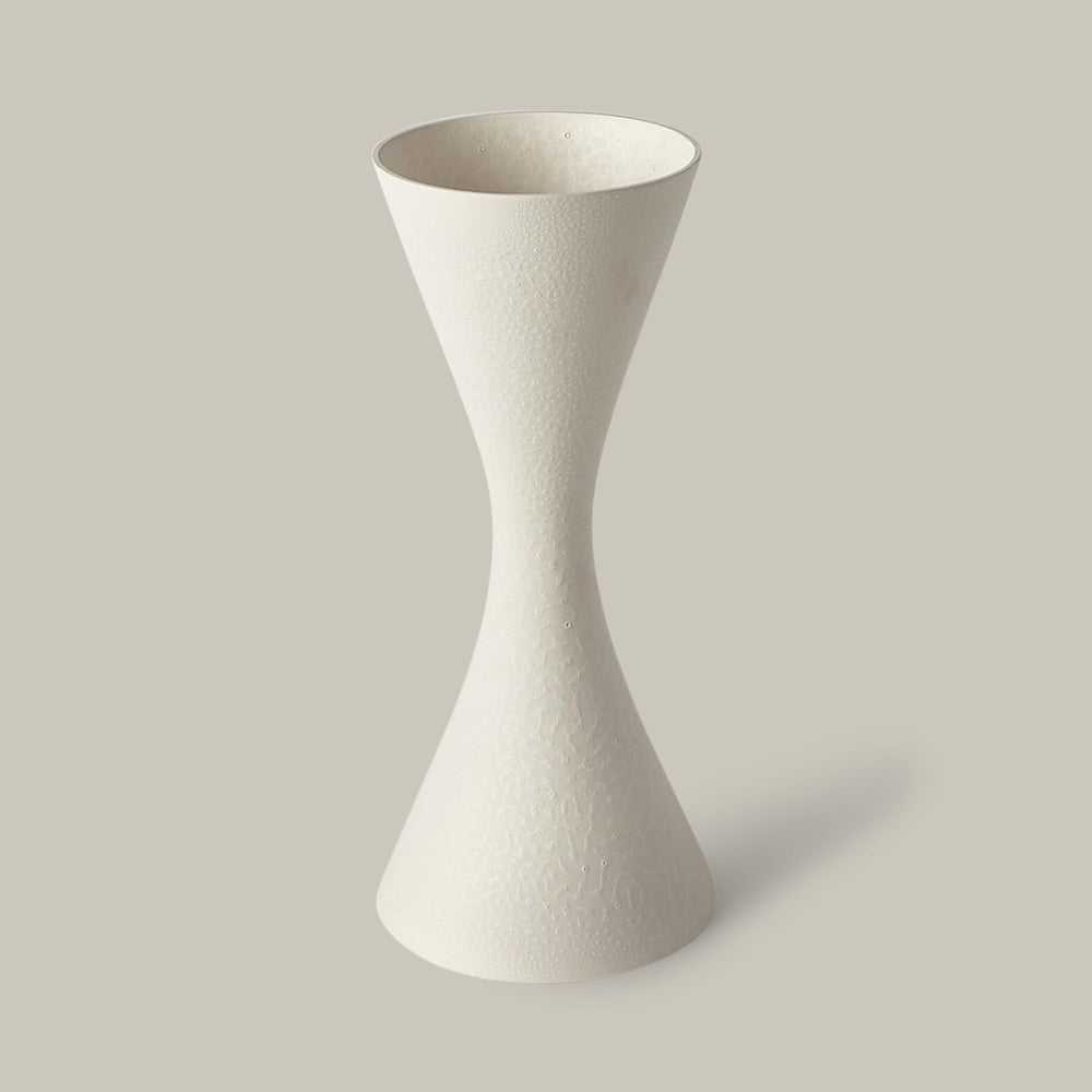 Lemieux et Cie Deoune Vase in matte white, sculptural hourglass-form ceramic vessel with textured surface, shown on neutral studio backdrop.