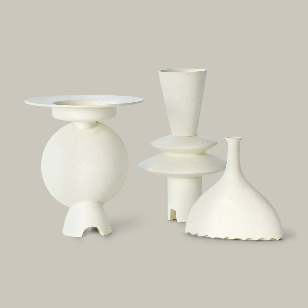 Lemieux et Cie Camille Geometric Vase in white, sculptural forms with tiered geometric bases and flared tops, shown on neutral studio backdrop.