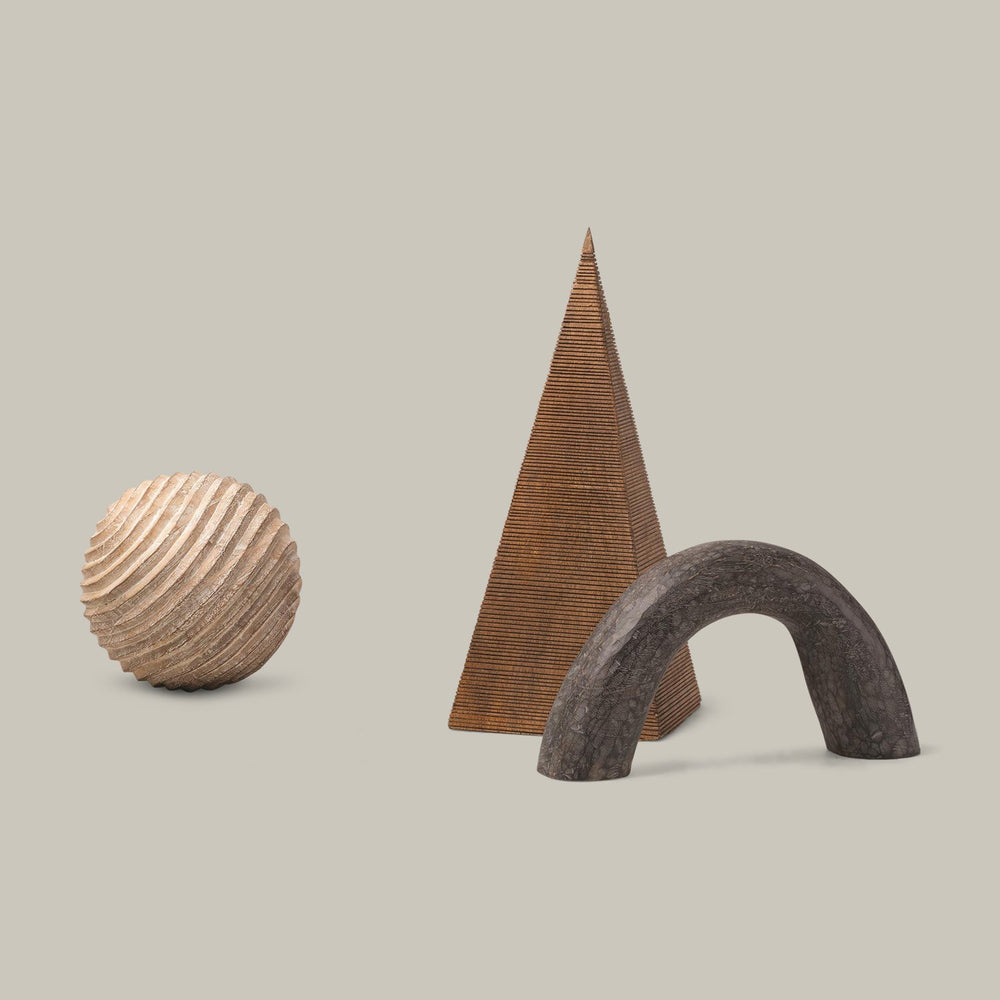 Lemieux et Cie Beaumont Wooden Pyramid, tall geometric cone with horizontal ribbing, shown with sculptural sphere and arch on neutral backdrop.