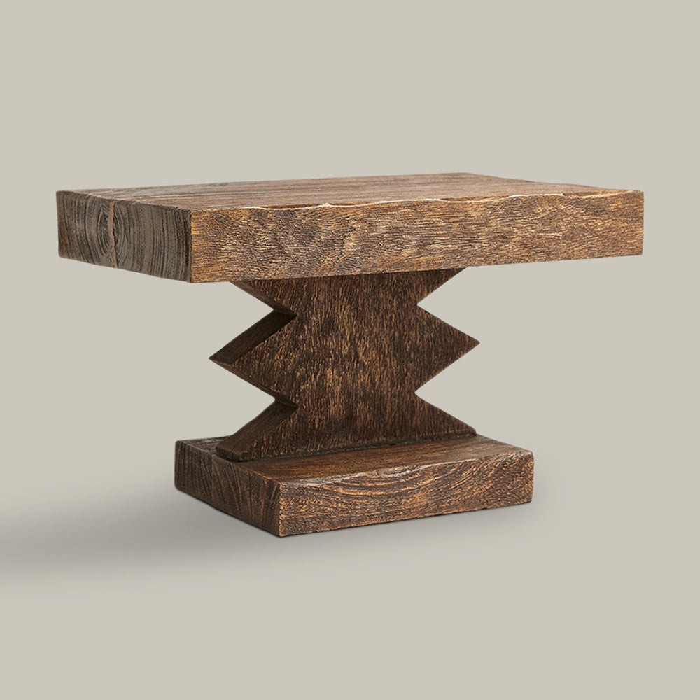 Lemieux et Cie Davin Pedestal, sculptural low table with geometric zigzag base and visible wood grain, shown on neutral studio backdrop.