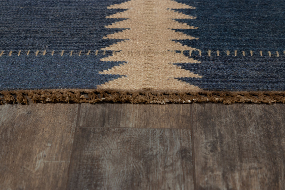 Lemieux et Cie Duar rug detail, handwoven pattern in deep indigo and tan with space-dyed color variation, shown on wood flooring.