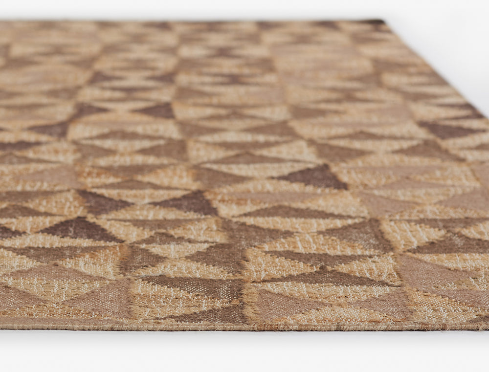 Lemieux et Cie rug in warm neutral tones with geometric pattern, woven textile flooring shown on white studio backdrop.