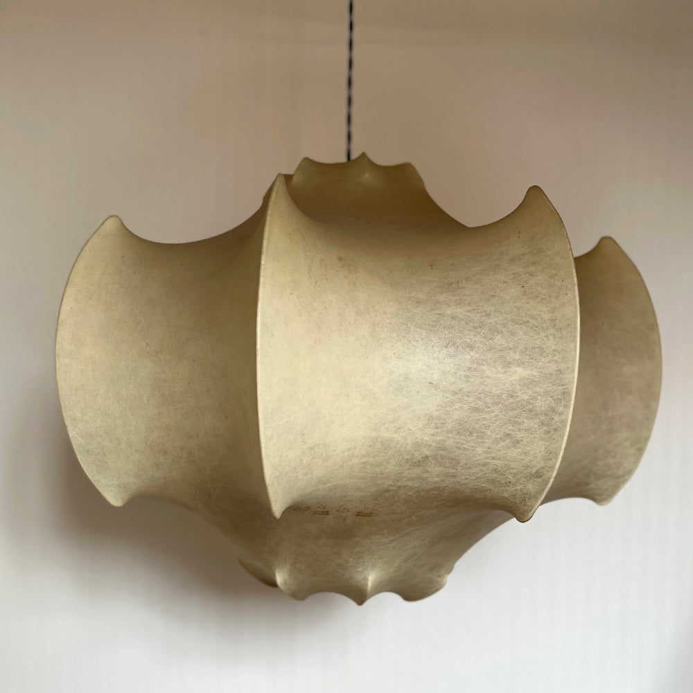 Lemieux et Cie Fontaine pendant light with sculptural scalloped shade in warm matte finish, suspended against neutral plaster wall in soft daylight.