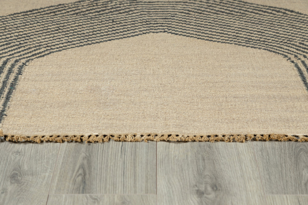 Lemieux et Cie Metlili rug in natural wool with charcoal striped border, handwoven carpet with antique wash finish shown on light wood flooring.