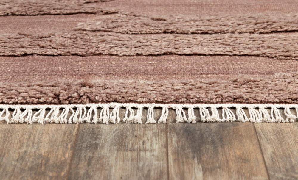 Lemieux et Cie Rafalla Rug detail showing hand-knotted fringe edge in natural undyed wool, high-low pile texture shown on wood flooring.