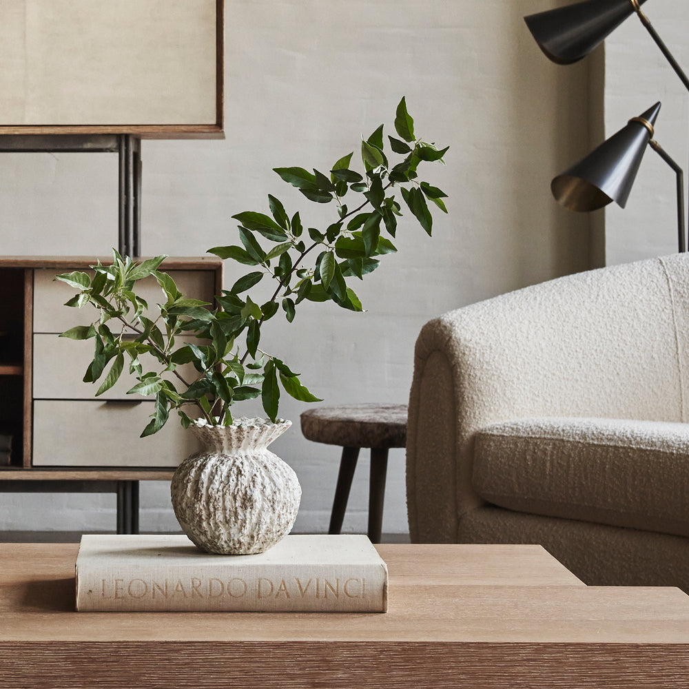 Lemieux et Cie Vilette Vase, textural ceramic vessel with organic ridged form, styled on wood coffee table in neutral sitting room with bouclé sofa.